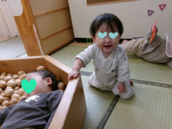 ハイハイから手をかけて、上手に座る姿勢になれました。うれしそうな表情です。